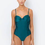 A model wearing an azure blue one-piece swimsuit with underwire and rouching detail.