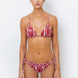 This image features the Chloe Granate Cheeky Tie Side Bikini Bottom by Mar de Lua, designed in a vivid granate red with a distinctive palm tree print. The bikini bottom is crafted with cheeky coverage and includes ruched back details for a flattering fit, along with adjustable rope-tie sides for an secure and adjustable waist.