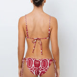 This image features the Chloe Granate Cheeky Tie Side Bikini Bottom by Mar de Lua, designed in a vivid granate red with a distinctive palm tree print. The bikini bottom is crafted with cheeky coverage and includes ruched back details for a flattering fit, along with adjustable rope-tie sides for an secure and adjustable waist.