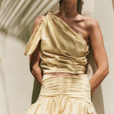 Image of a woman wearing matching yellow skirt and top. Both have rouching on the sides.