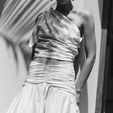 Black and white image of a woman wearing a matching skirt and top. Both have rouching on the sides.