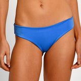 Blue bikini bottom worn by a person on a plain background.
