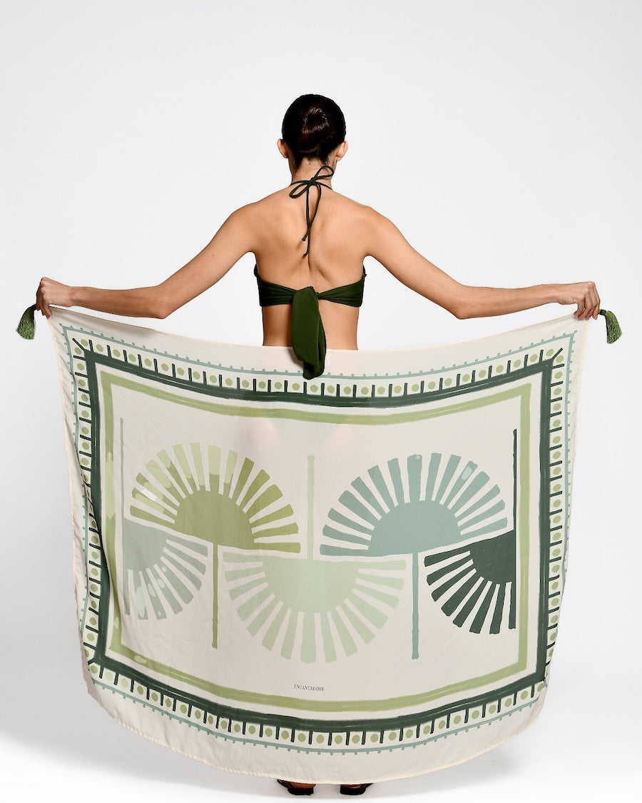 Woman holding a green and white patterned towel with a white background.