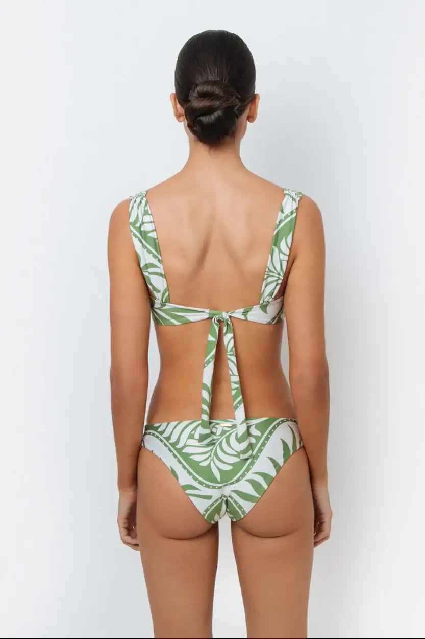 A model wearing a green palm leaf print bikini with full-coverage design bottoms.