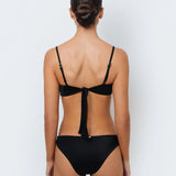 A model wearing a black bikini top with white stitching and matching full coverage bottoms.