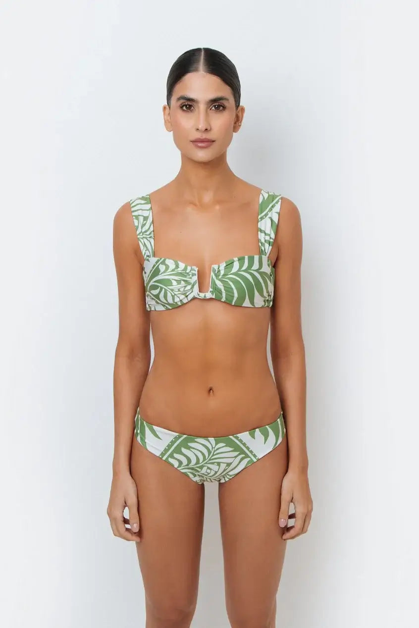 A model wearing a green palm leaf print bikini with full-coverage design bottoms.
