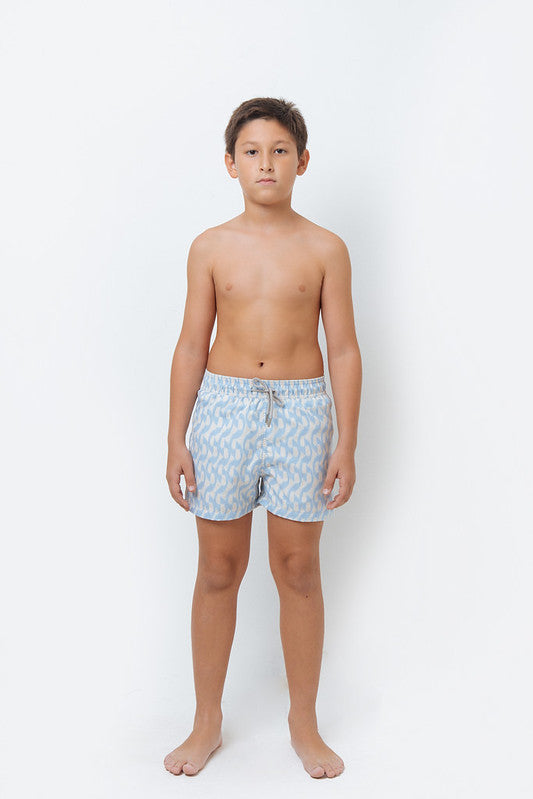 A boy wearing icy blue print swim trunks.