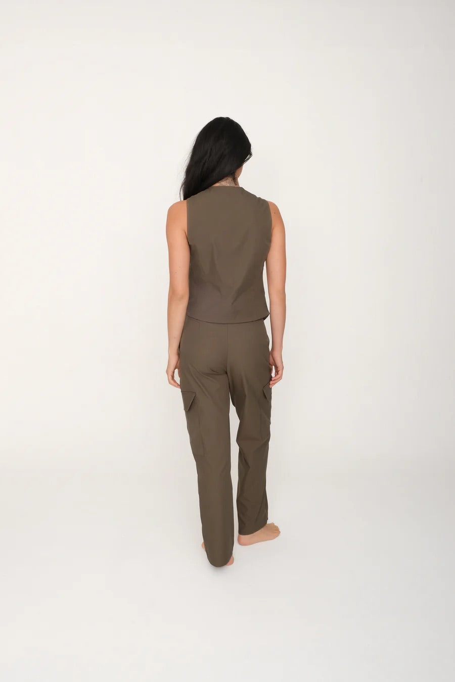Person wearing a sleeveless top and pants set on a white background.