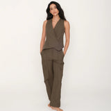 Woman wearing a brown sleeveless top and pants on a white background.