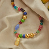 A gold-plated pineapple pendent necklace with oversized multicolored beads.