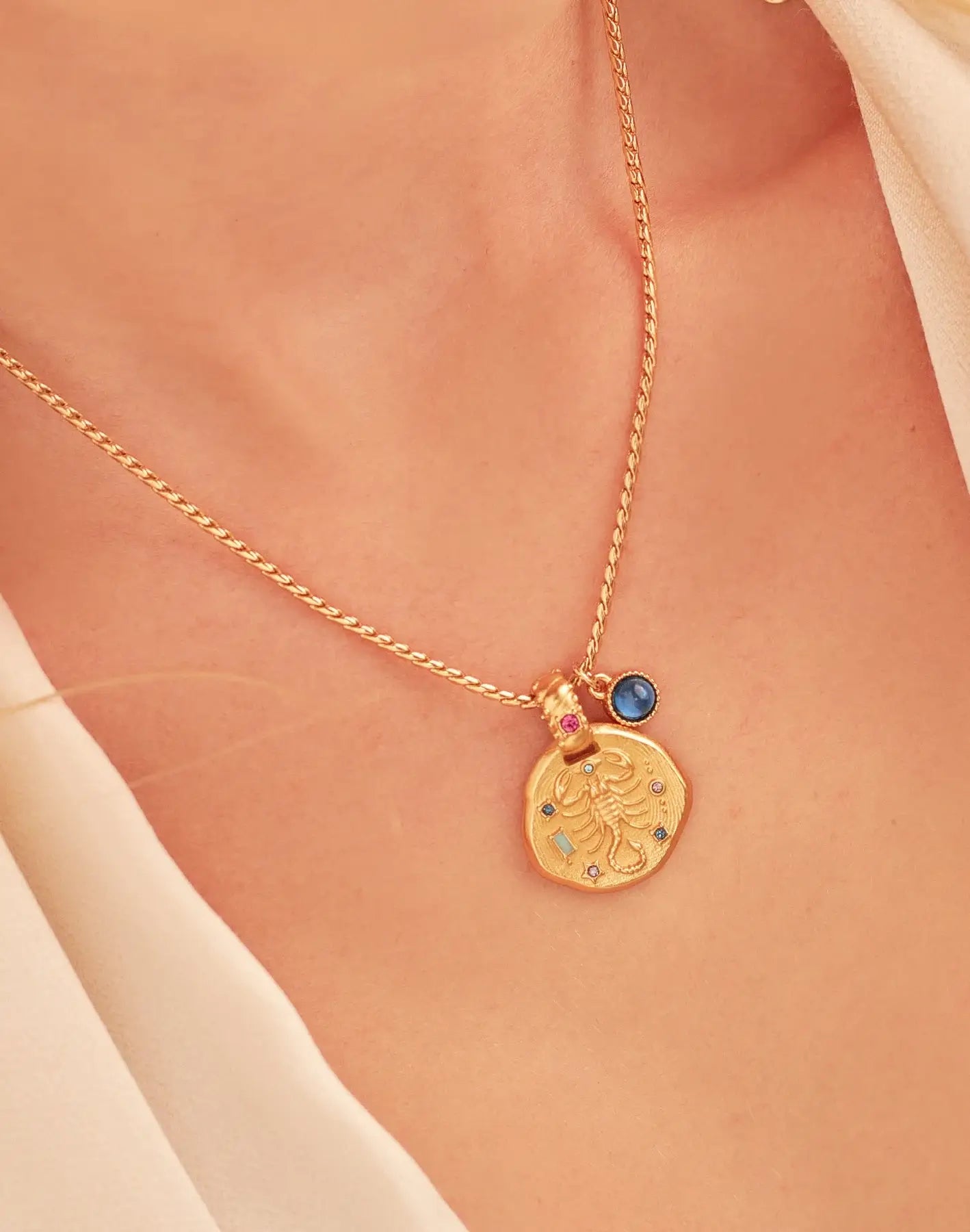 A 24k gold-plated necklace for Scorpio zodiac pendant, accompanied by a natural stone charm.