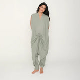 Woman wearing a green flowy jumpsuit on a white background.