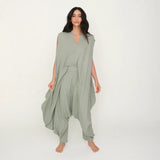 Woman wearing a green flowy jumpsuit against a white background.