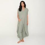 Woman wearing a light green jumpsuit on a white background.