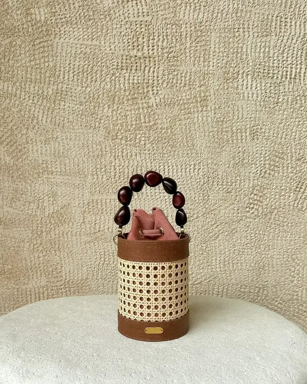 Small handbag with a textured handle on a textured surface.
