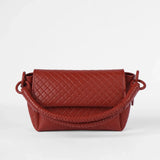 Red quilted handbag on a white background.