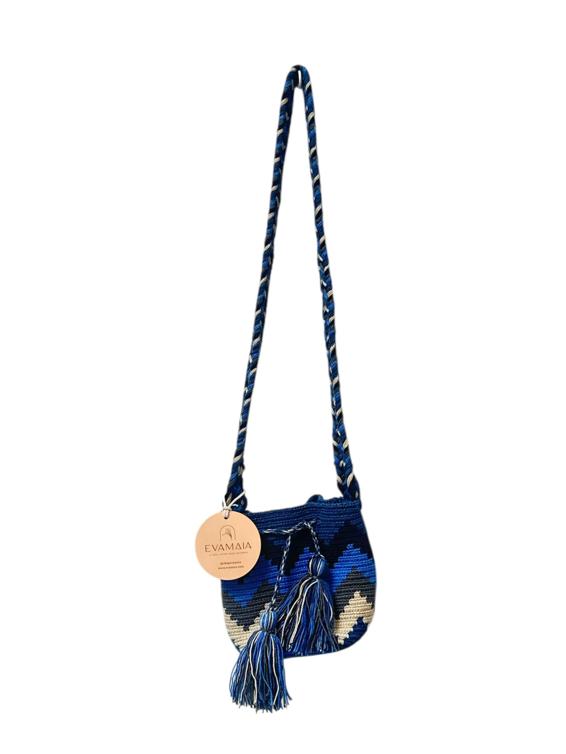 Blue and white handbag with tassels on a white background.