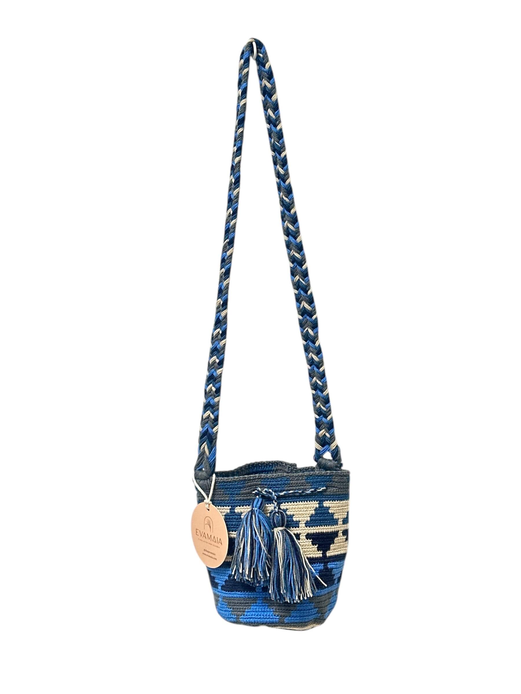 Blue and white patterned bucket bag with braided handle on a white background.