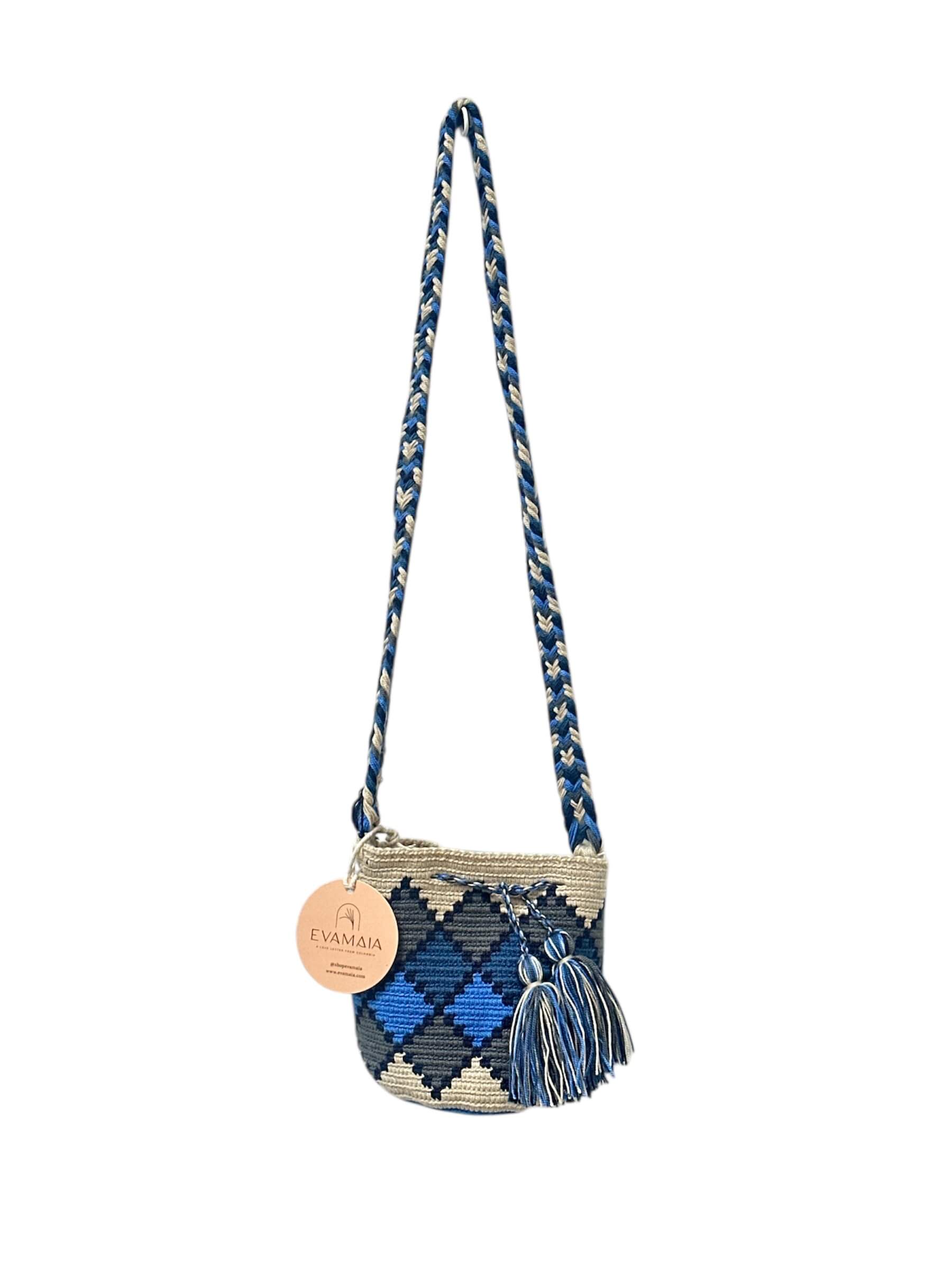 Blue and white patterned handbag with tassels on a white background.