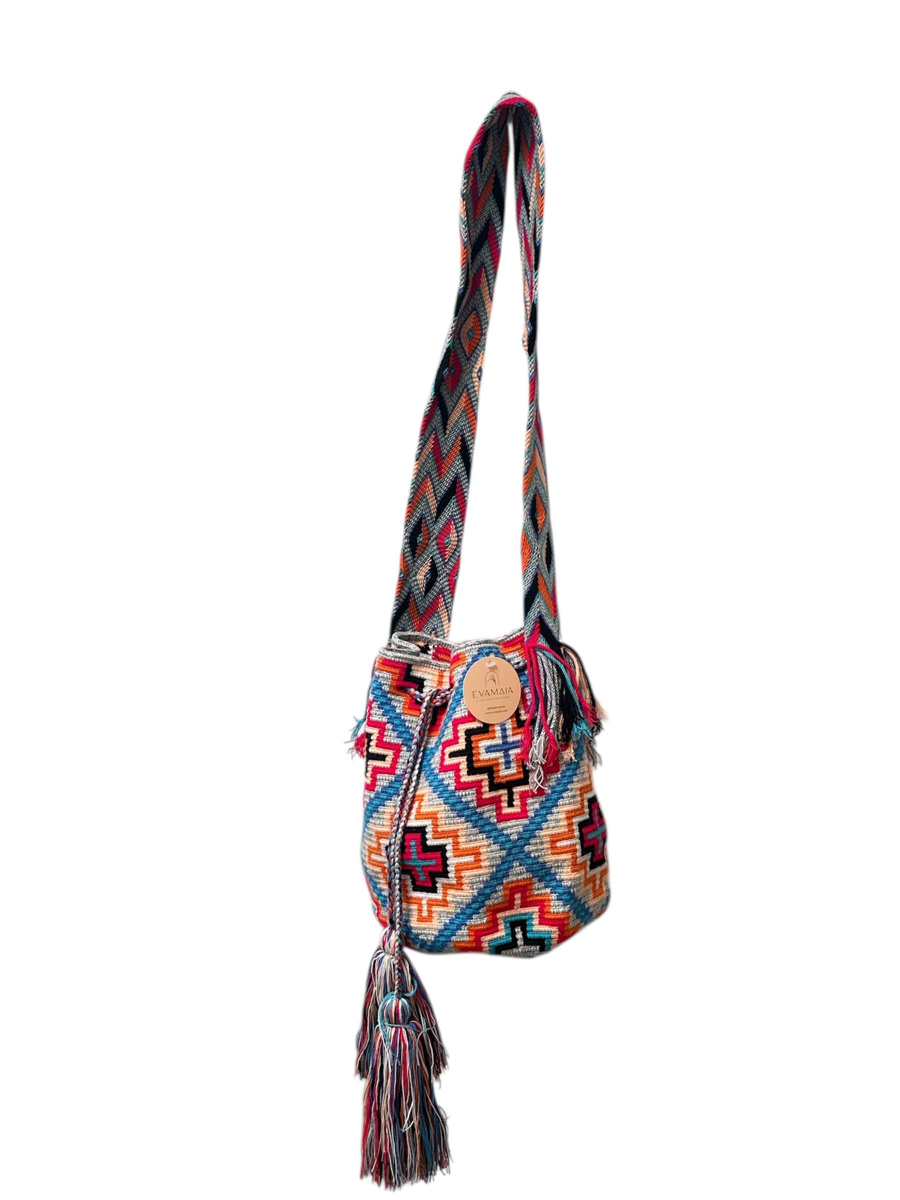 Colorful handbag with geometric pattern and tassel on a white background.
