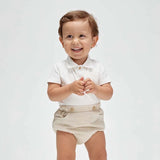 A baby wearing a white soft cotton polo shirt and beige shorts with a faux pocket, standing against a white background.