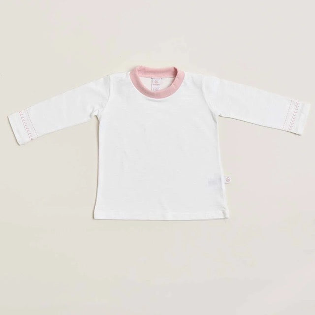 A long sleeve white shirt for girls with a pink collar and pink stitching on the sleeves, laid flat on a neutral background.
