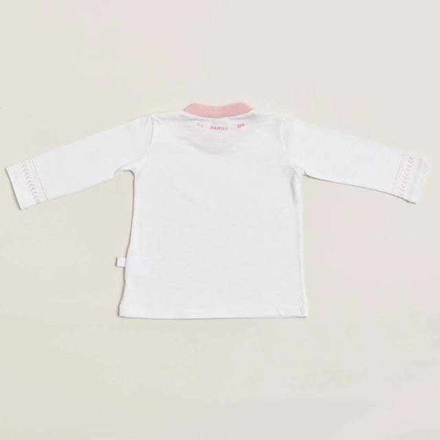 The back of a long sleeve white shirt for girls with a pink collar and pink stitching on the sleeves, laid flat on a neutral background.