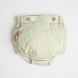 A light green diaper cover with wooden button accents and a embroidered bear detail.