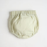 A light green diaper cover with wooden button accents and a embroidered bear detail, the back is just plain green.