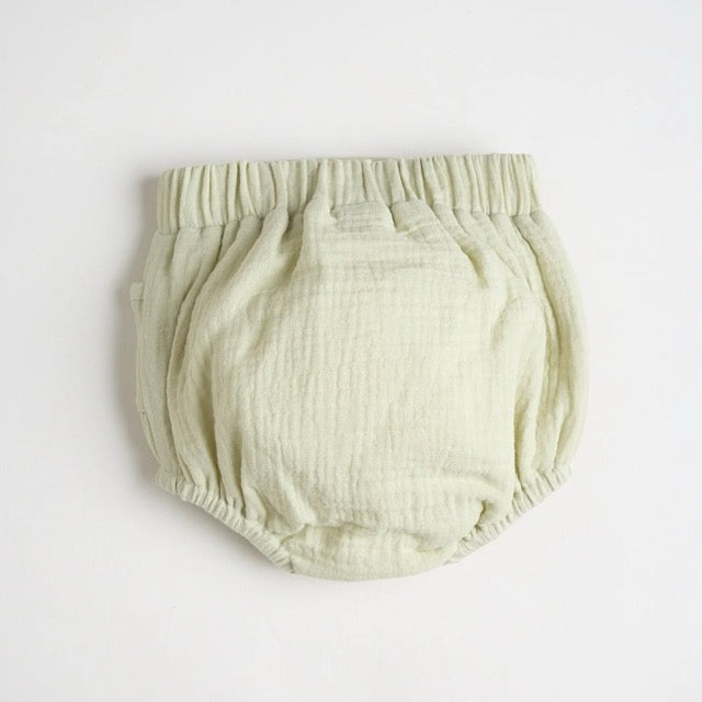 A light green diaper cover with wooden button accents and a embroidered bear detail, the back is just plain green.