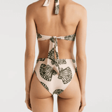 A a bikini with a halter top design and a shell print, featuring a crisscross design at the front and an adjustable tie at the back, with high waisted cheeky bikini bottoms, worn by a model.