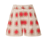 A model wearing Encantadore's Fede Red Star Shorts, which are knee-length with a wide-leg fit and a red star pattern.