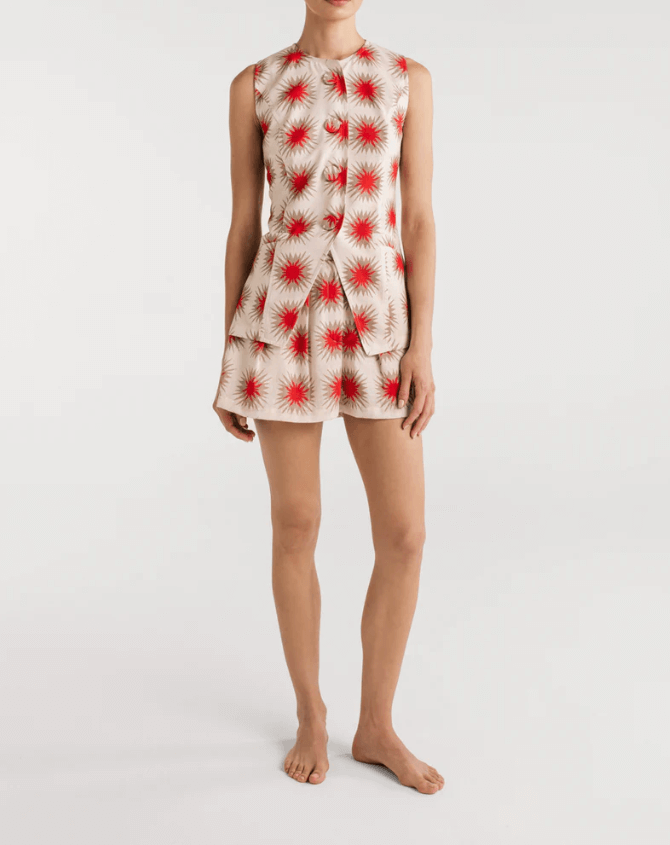A model wearing Encantadore's Fede Red Star Shorts, which are knee-length with a wide-leg fit and a red star pattern.