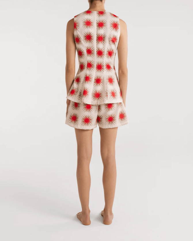 A model wearing Encantadore's Fede Red Star Shorts, which are knee-length with a wide-leg fit and a red star pattern.