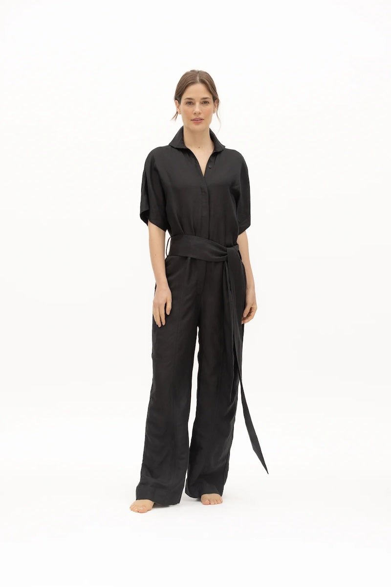 Women wearing a black jumpsuit with matching belt.