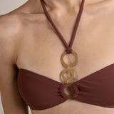 Brown halter bikini top with gold circular design on a white background.