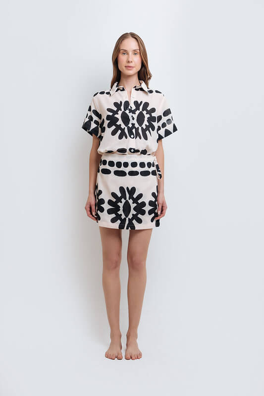 Model wearing a stylish black and white abstract print shirt and skirt set made from high-quality polyester with a linen-like feel.
