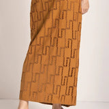 Close up image of a woman wearing an embroidered skirt. She is standing against a white background. The purpose of this image is to highlight the skirt.