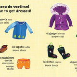 A page from 'Mis primeras palabras - Baby's First Words' featuring illustrations of all different kinds of clothing and their names in Spanish and English.