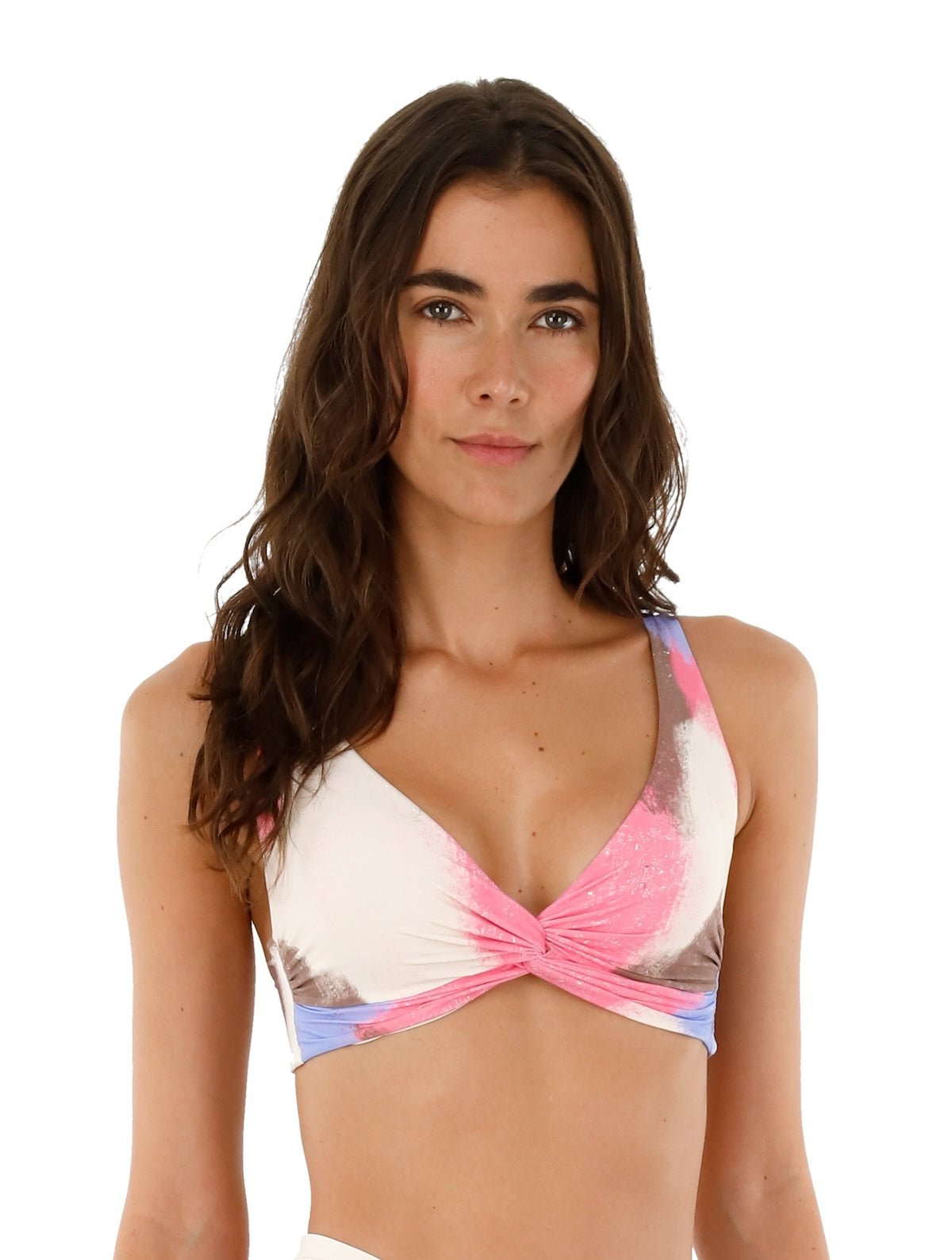Image of a woman wearing a tie die swimsuit top by Malai Swimwear. She's smiling and standing on a white background. The purpose of this image is to highlight the bikini.