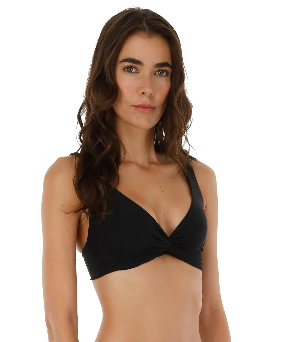 Woman wearing a black bikini top on a white background.