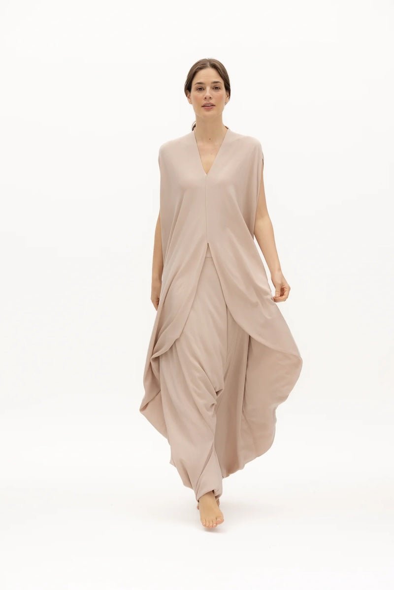 Image of woman wearing a flowy jumpsuit against a white background. The purpose of this image is to highlight the jumpsuit from NAOS, which is for sale at EVAMAIA boutique in Studio City, CA.