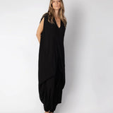 Image of woman wearing a flowy jumpsuit against a white background. The purpose of this image is to highlight the jumpsuit from NAOS, which is for sale at EVAMAIA boutique in Studio City, CA.