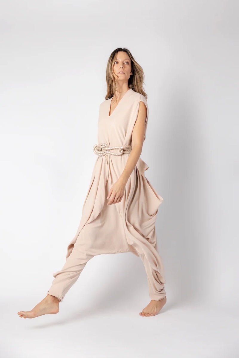 Image of woman wearing a flowy jumpsuit against a white background. The purpose of this image is to highlight the jumpsuit from NAOS, which is for sale at EVAMAIA boutique in Studio City, CA.