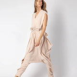 Image of woman wearing a flowy jumpsuit against a white background. The purpose of this image is to highlight the jumpsuit from NAOS, which is for sale at EVAMAIA boutique in Studio City, CA.