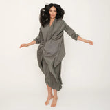 Woman wearing the green Miaroma dress against a white background