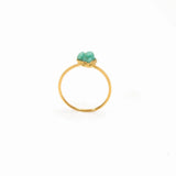 Close up image of a dainty gold ring with a raw emerald stone on it. The purpose of this image is to highlight the ring because it is for sale at EVAMAIA boutique in Studio City, CA and online.