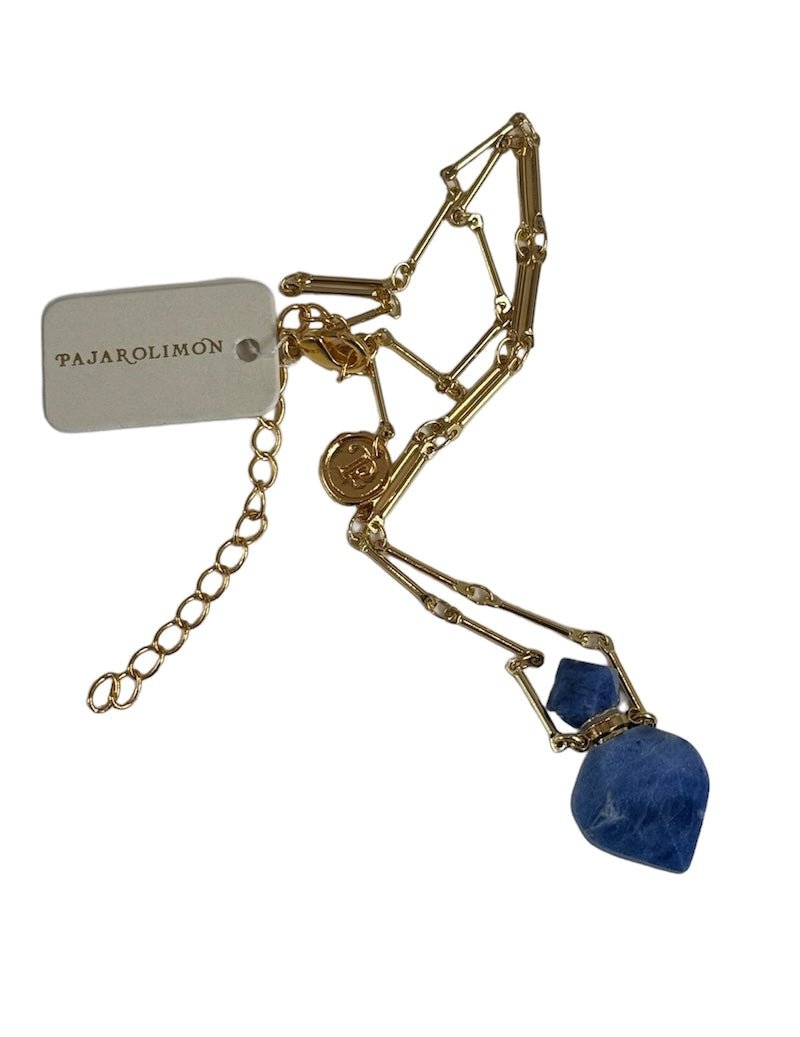 Image of a gold necklace holding a sodalite stone perfume bottle. The purpose of this image is to highlight the necklace. This necklace is made in Colombia by Pajarolimon and sold at EVAMAIA boutique.