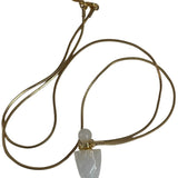 Image of a gold necklace holding a quartz perfume bottle. The purpose of this image is to highlight the necklace. This necklace is made in Colombia by Pajarolimon and sold at EVAMAIA boutique.