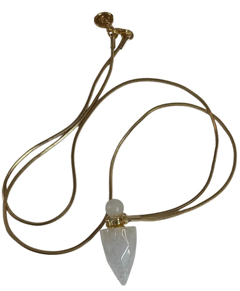 Image of a gold necklace holding a quartz perfume bottle. The purpose of this image is to highlight the necklace. This necklace is made in Colombia by Pajarolimon and sold at EVAMAIA boutique.